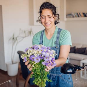 woman putting out flowers in apartment 